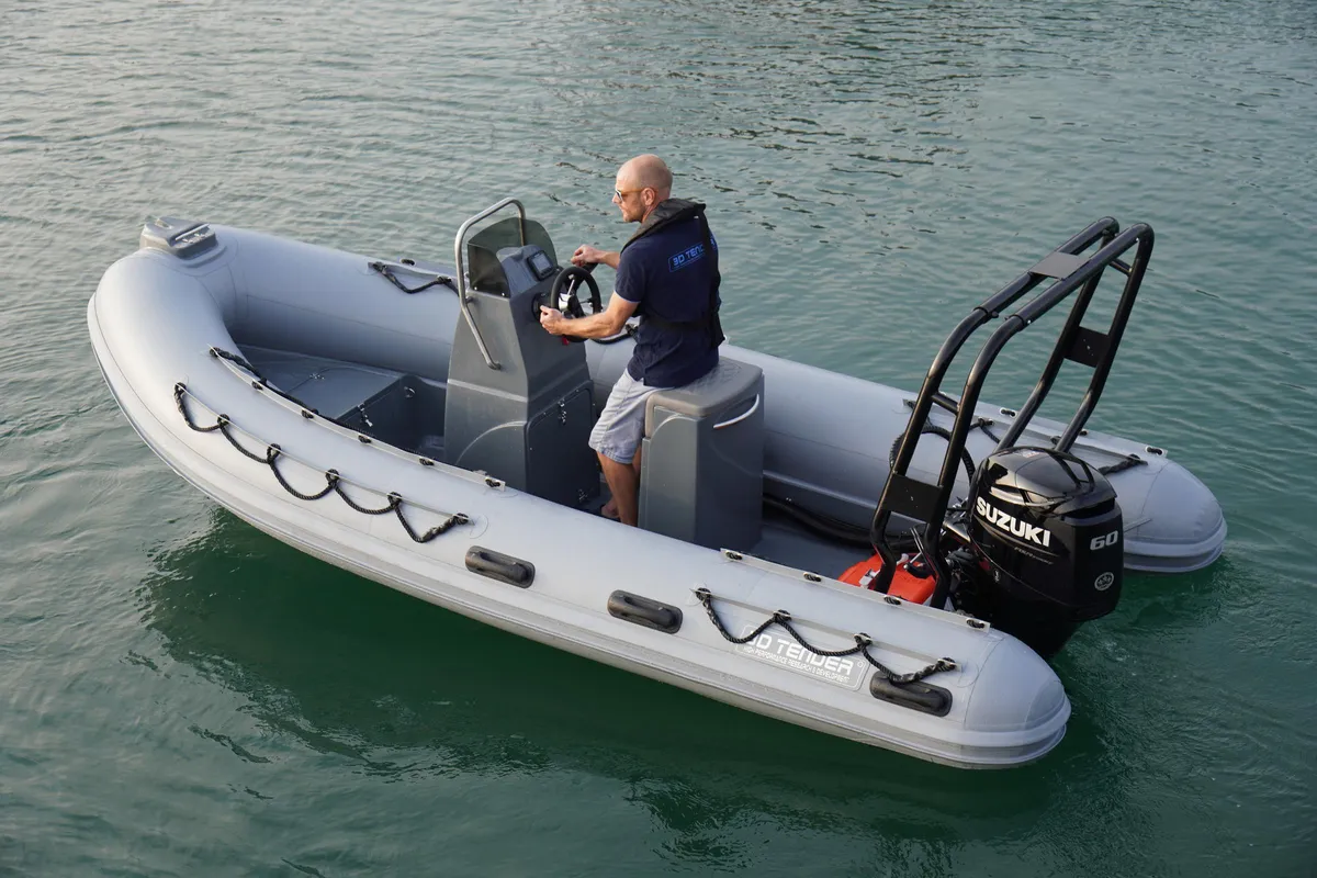 3D Tender XPRO 490: A man is steering a rubber boat on the water