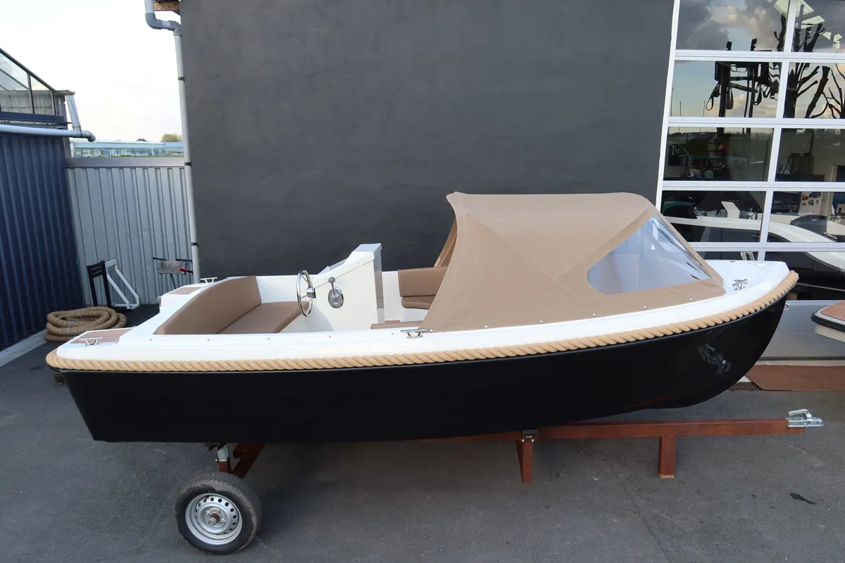 4-Family 490 de Luxe: Boot auf einem Anhänger neben einem Bootshaus