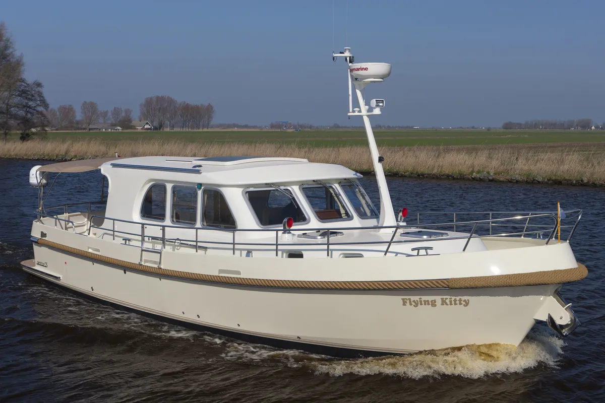 Aquanaut Drifter CS 1200 OK: Yacht à moteur en acier doté d'un cockpit ouvert, naviguant sur un canal