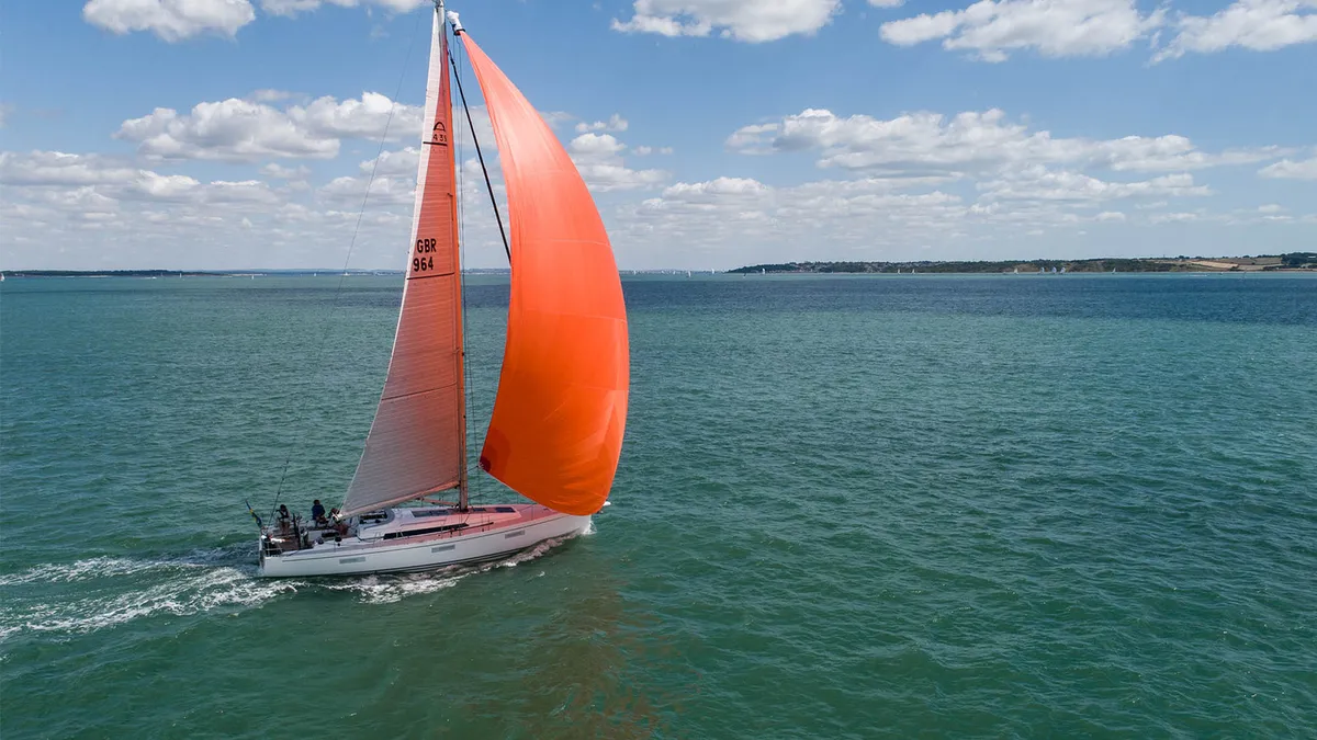 Arcona Yachts 435 Mk II: Segelboot mit einem orangefarbenen Spinnaker auf dem Meer