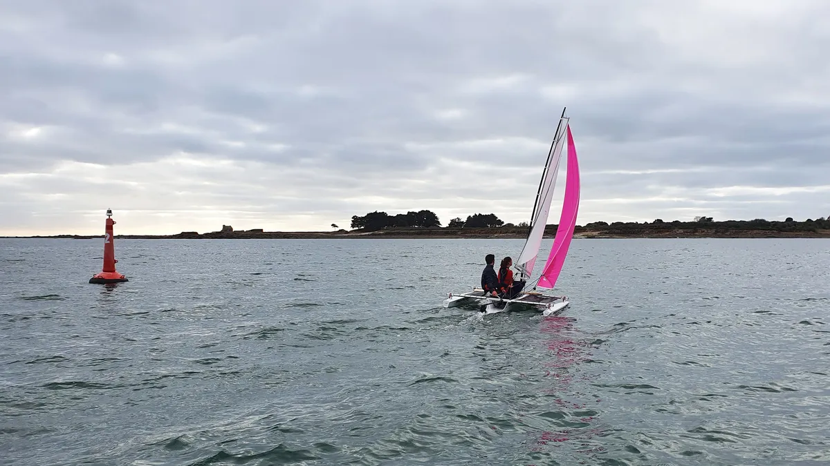 Astus Boats 14.5: Katamaran mit einem rosa Segel auf dem Meer