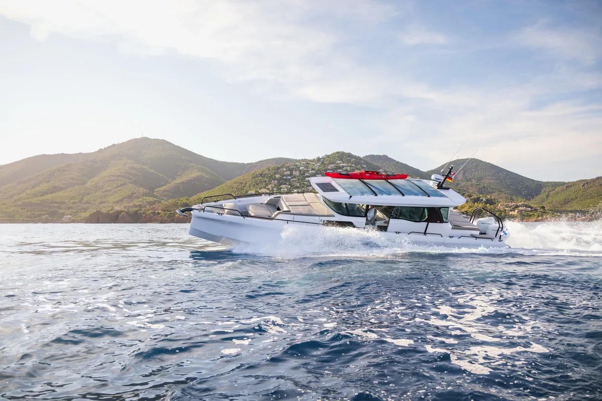 Axopar 45 XC Cross Cabin: Boat cruising at sea with mountains in the background