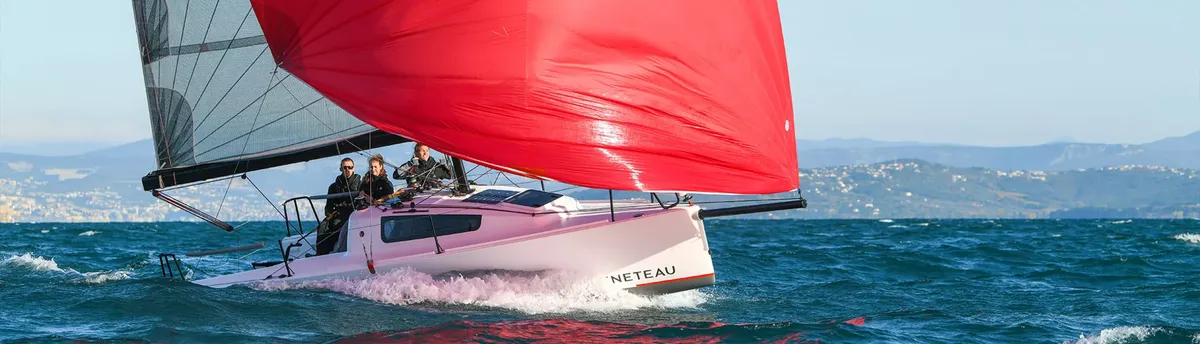 Beneteau First 24 SE: Segelboot mit rotem Spinnaker auf dem Meer