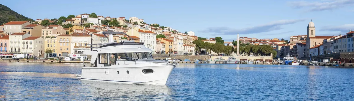 Beneteau Swift Trawler 41 Fly: Boat cruising off a coastal town