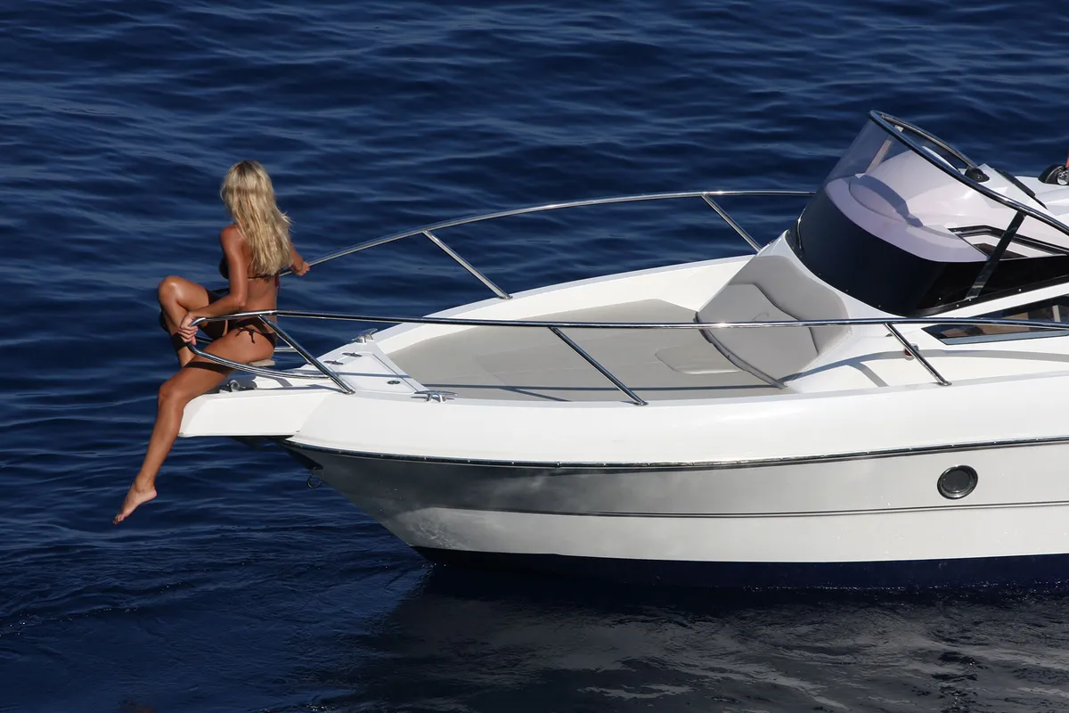Capelli Cap 25 WA: Woman sitting on the bow rail of a boat