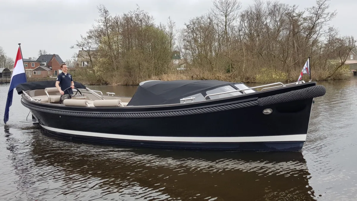 Jan van Gent JVG 10.35 Soft Top: A dark blue boat cruising on the water