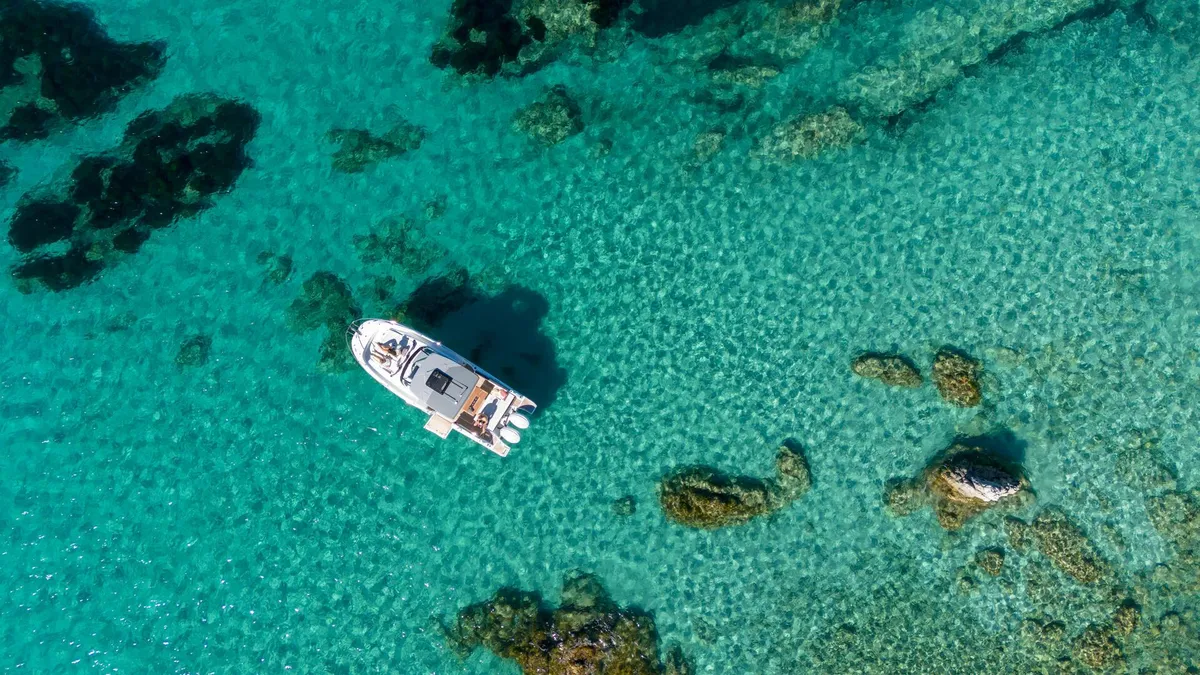 Jeanneau Cap Camarat 9.0 WA: Boat on turquoise water, aerial view