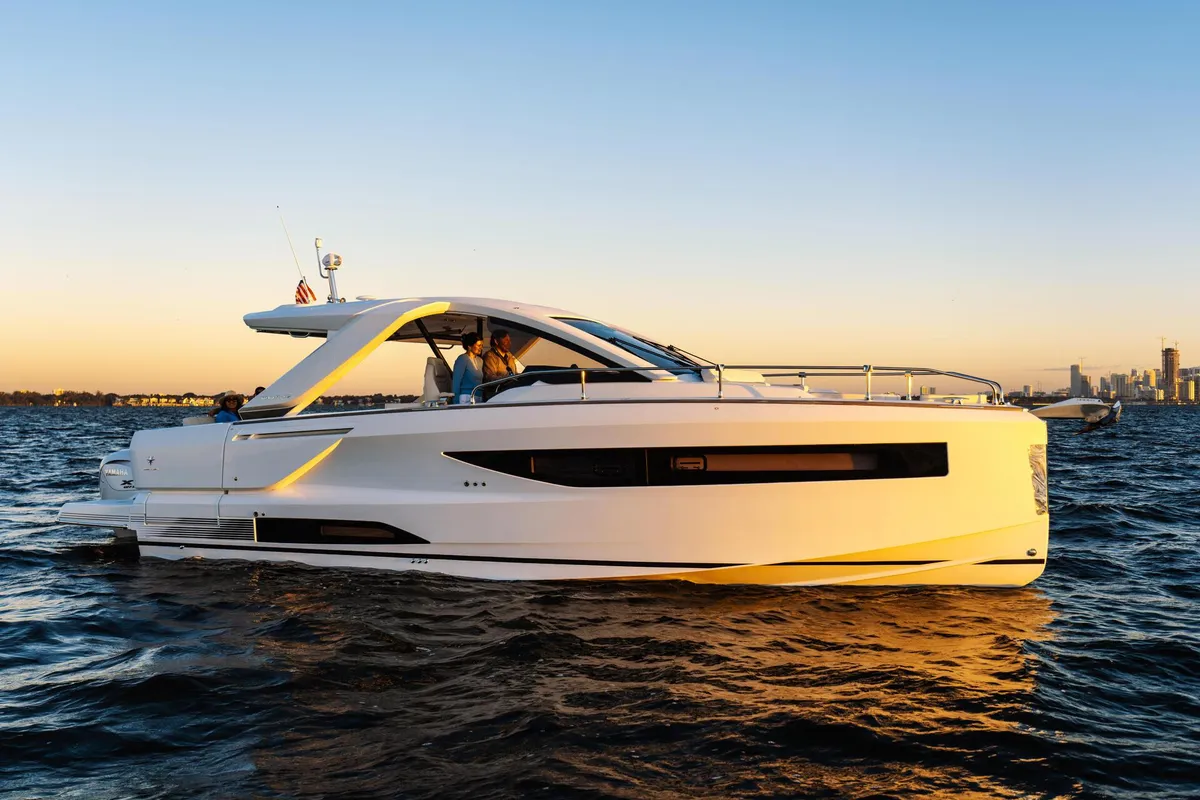 Jeanneau DB/37 OB: A white motorboat cruising at sunset