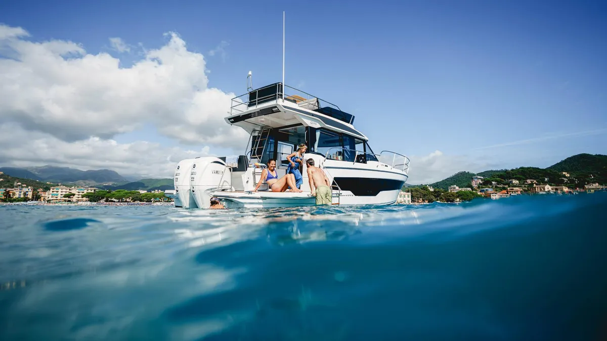 Jeanneau Merry Fisher 1095 Fly Série2: Des personnes nageant près d'un yacht à moteur