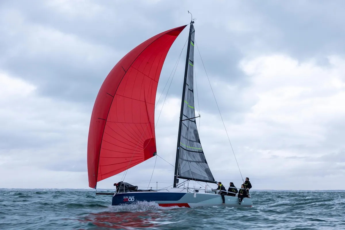 Jeanneau Sun Fast 30 One Design: Segelboot mit rotem Spinnaker auf dem Meer