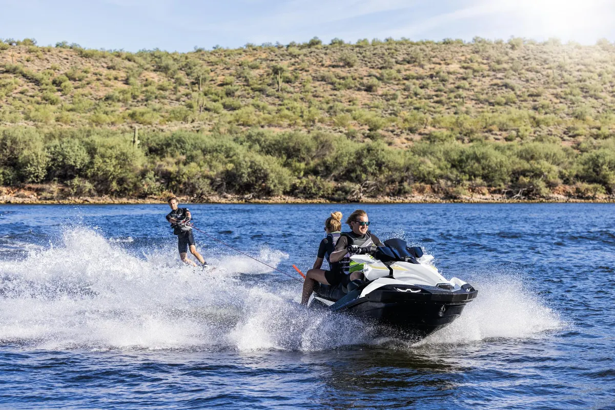 Kawasaki Jet Ski Ultra 160LX: A jet ski pulls a water skier across a lake
