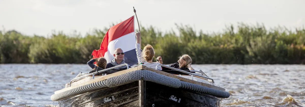 Langweerder Sloep 7.50 Classic: Family on a boat with a flag