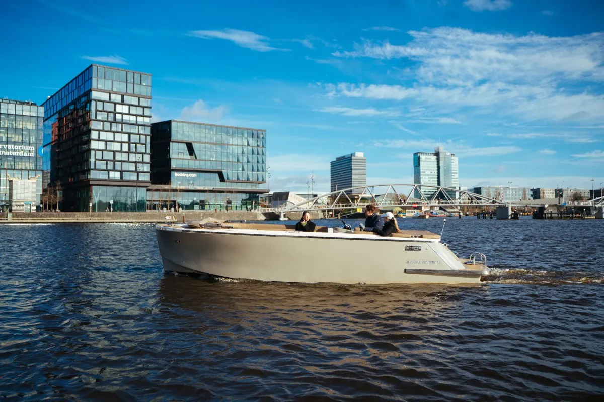 Lifestyle 780 Tender: Un bateau naviguant sur l'eau avec un paysage urbain en arrière-plan