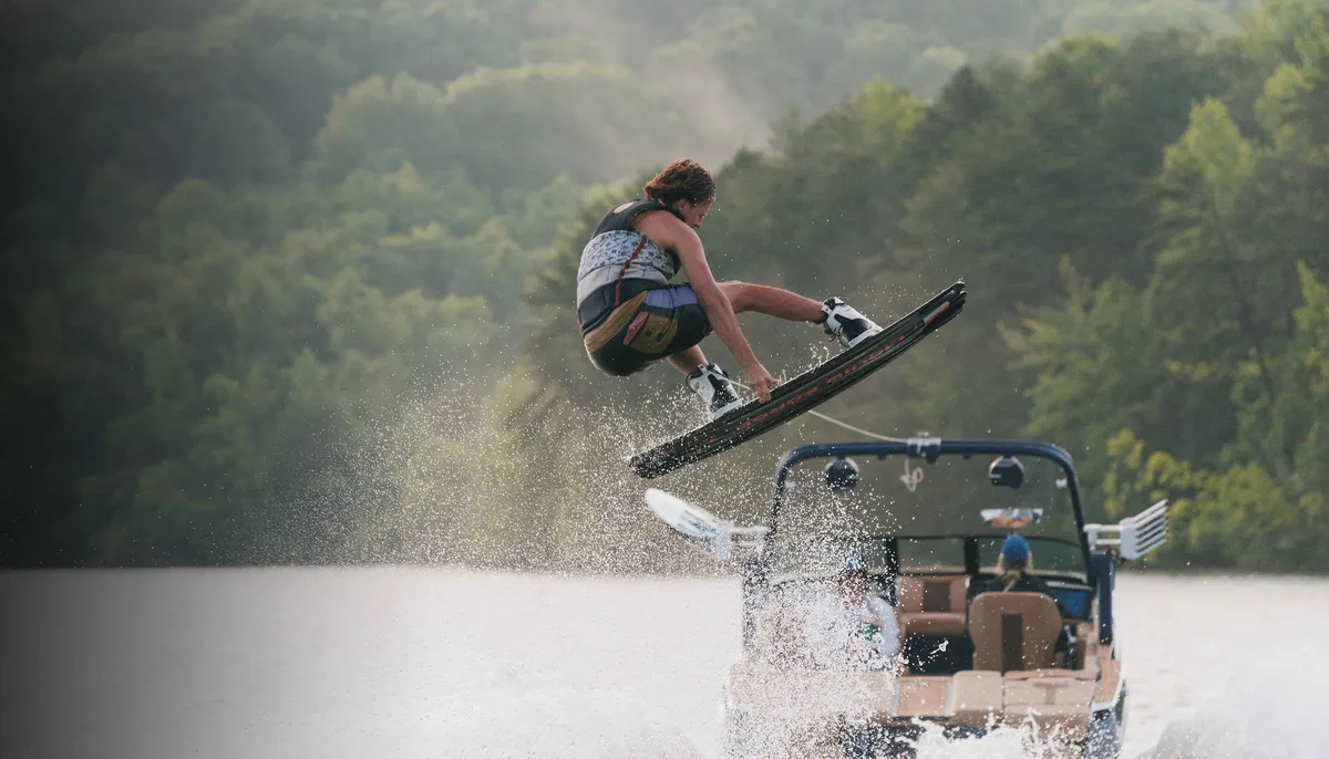 MasterCraft XT23: Un wakeboarder effectuant un saut derrière un bateau