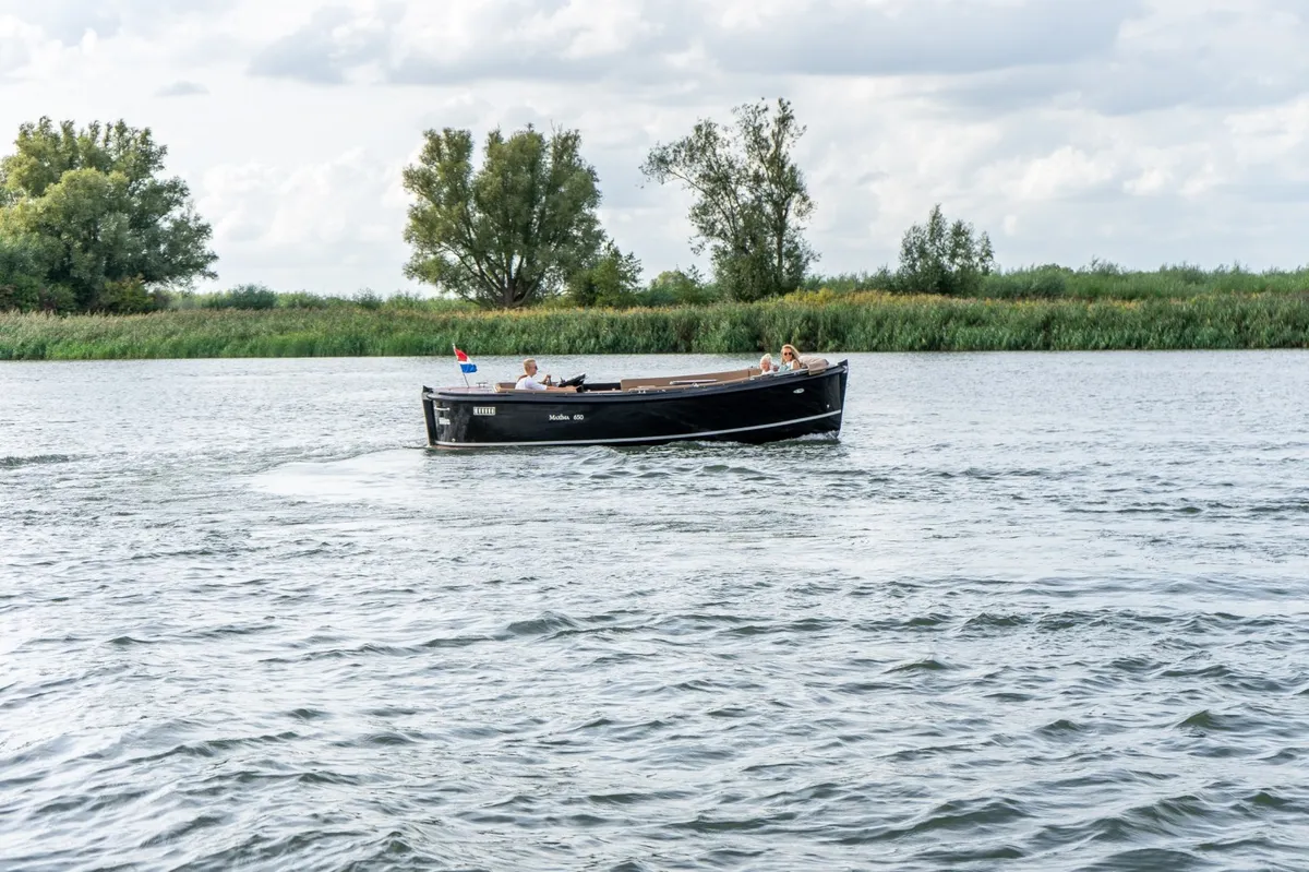 Maxima 650 Flying Lounge Elektrisch: Ein schwarzes Boot gleitet über das Wasser