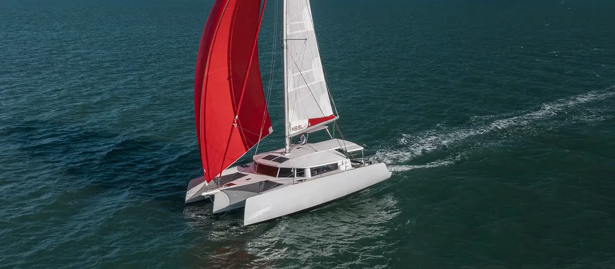 Neel Trimarans 43: Trimaran mit roten Segeln auf dem Meer