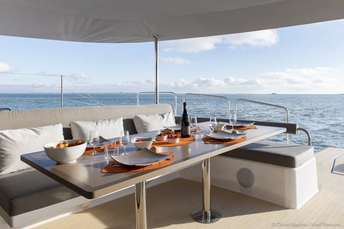 Neel Trimarans 65 Evolution: Deck table laid out with a view of the sea