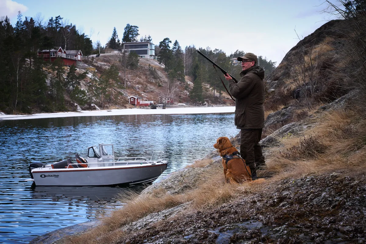 Ockelbo B18DC: Hunter with a dog by a boat