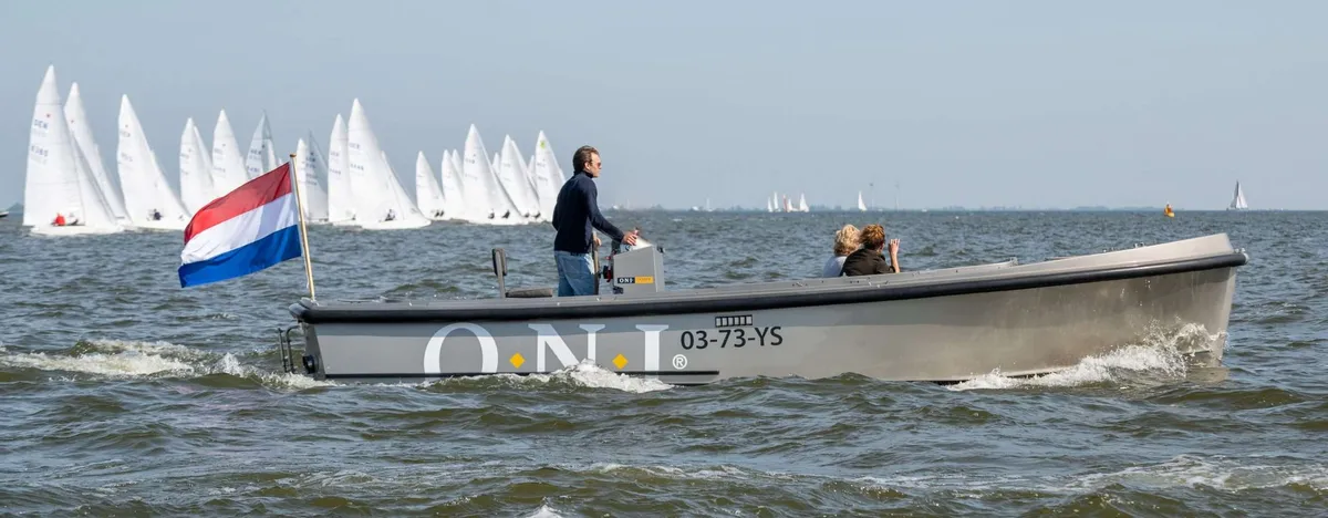 ONJ Motorboten Tender 820: Un bateau gris naviguant avec des voiliers en arrière-plan