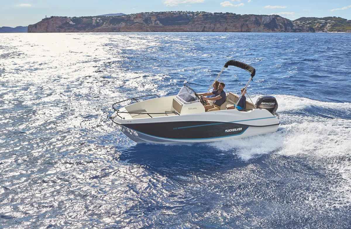 Quicksilver 555 Open: Ein Boot fährt auf dem Meer, im Hintergrund ist die Küste zu sehen