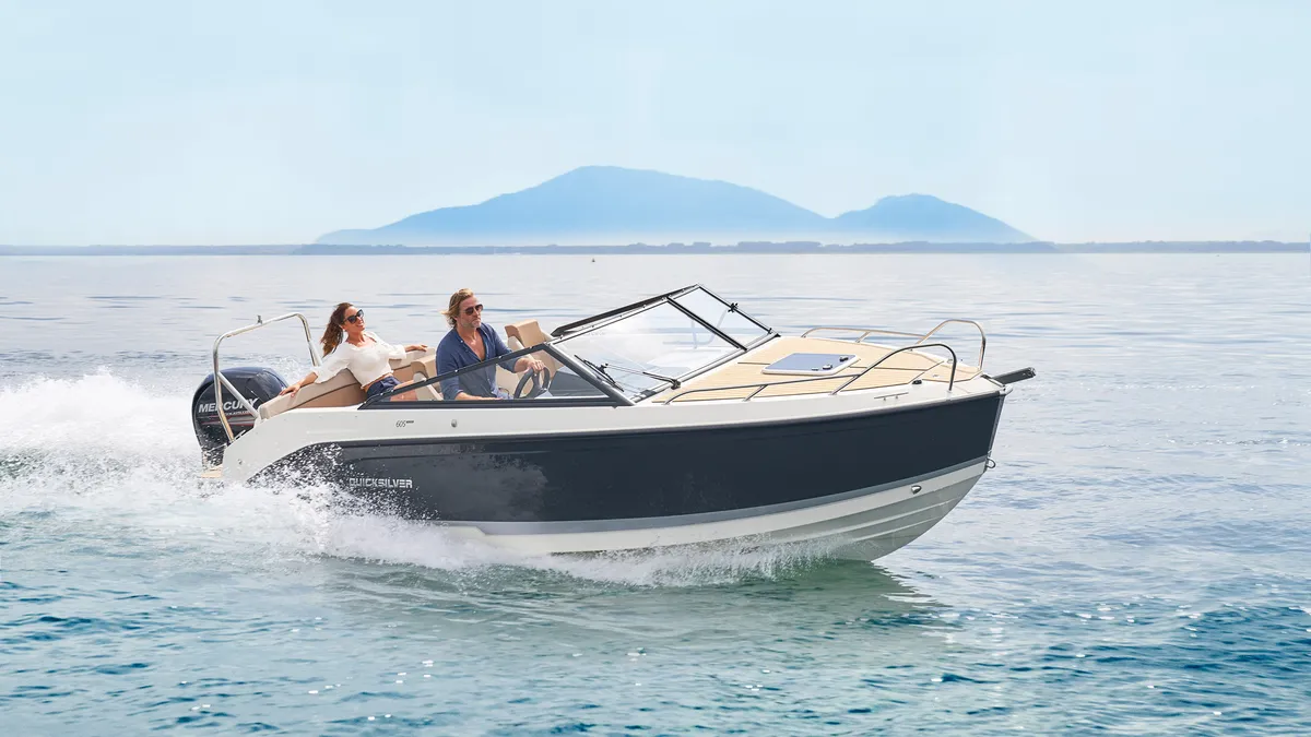 Quicksilver 605 Cruiser: Ein Boot auf See vor dem Hintergrund von Bergen