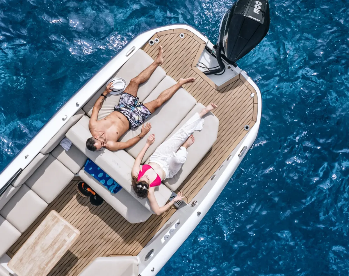 Rand Boats Supreme 27: Ein Paar, das auf einem Boot ein Sonnenbad nimmt