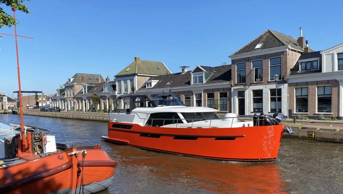 Super Lauwersmeer Discovery 47 AC: Orange motorboat in a canal