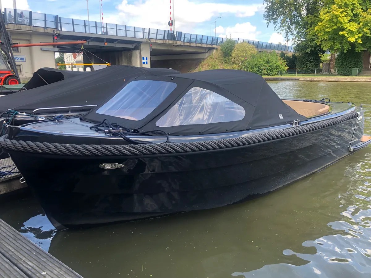Topcraft 605 Tender: Ein schwarzes Motorboot, das an einer Brücke festgemacht ist