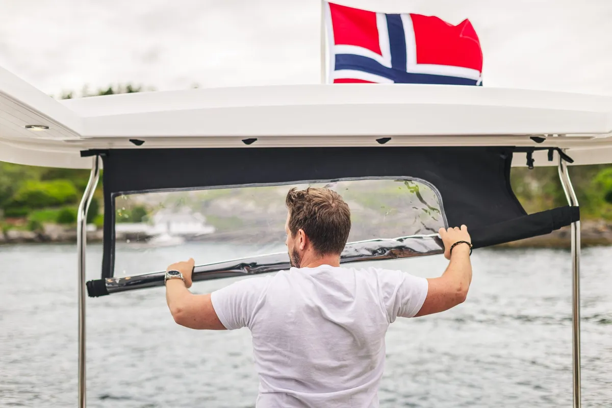 Viknes S40 Panorama: Man opening a sun awning next to a flag